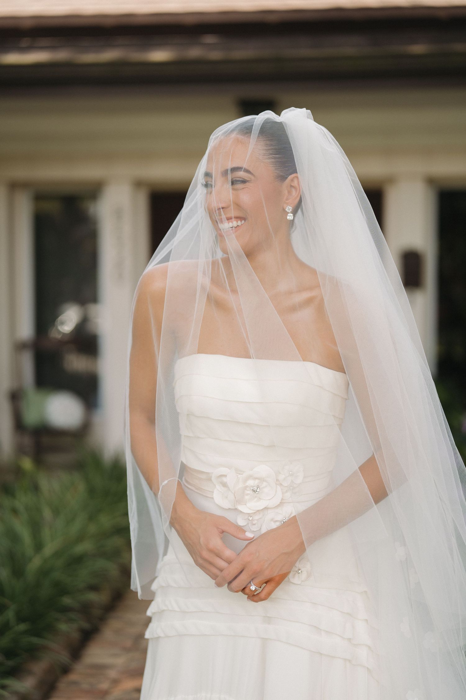 Close-up portrait of bride in strapless gown with flowing veil.