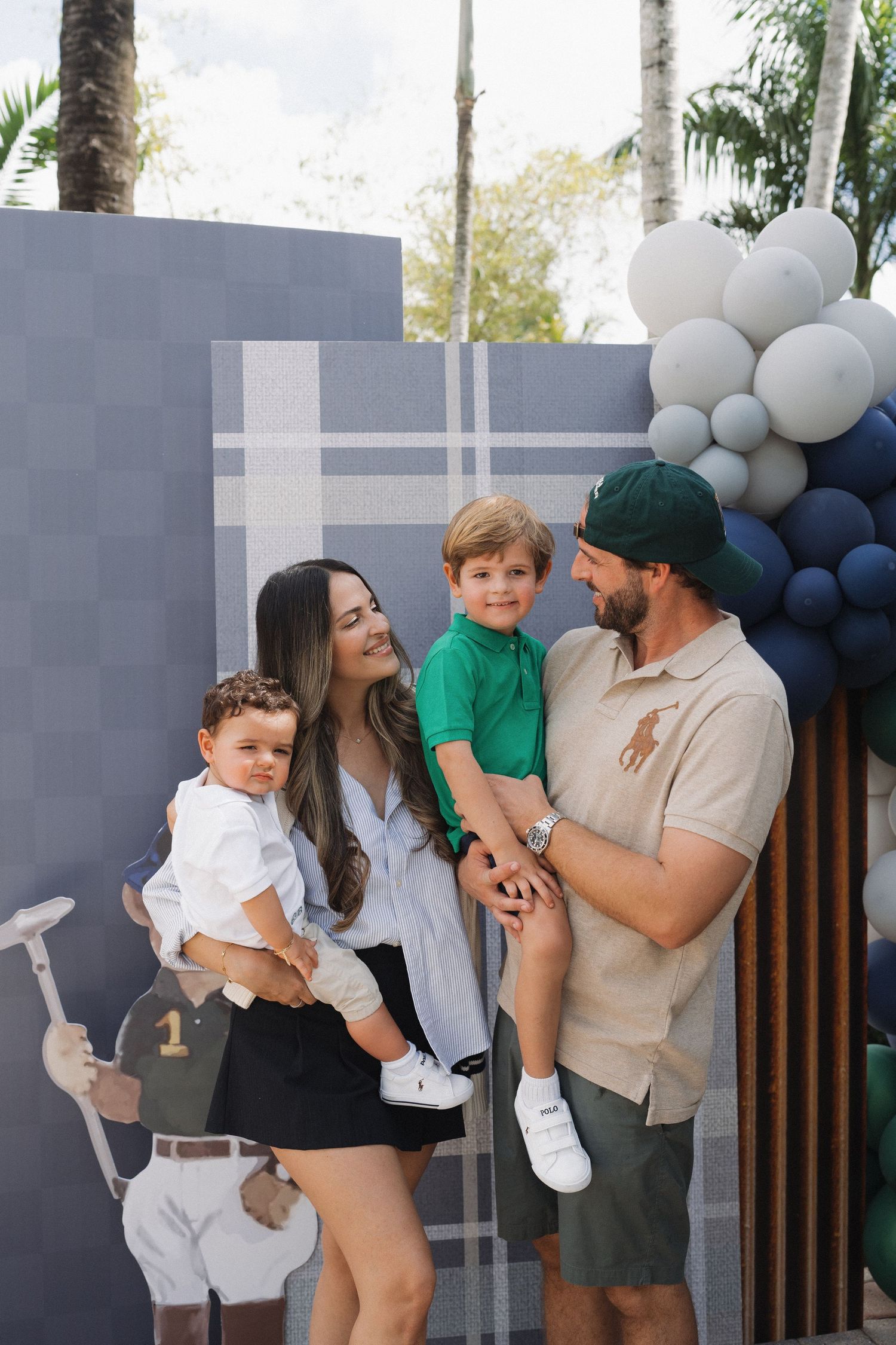 First birthday celebration with blue and white balloon arch decoration in outdoor setting.