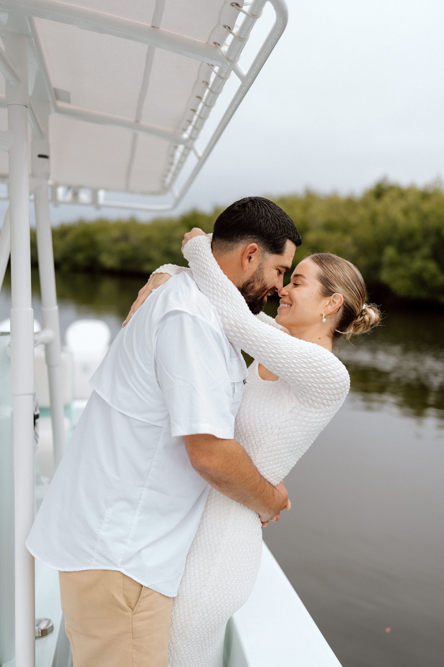 Intimate couple portraits on boat dock wearing white and khaki outfits.