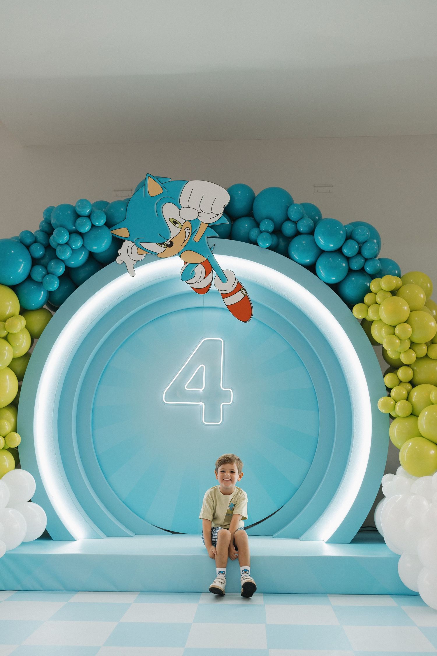 Sonic-themed birthday backdrop featuring number 4 and blue balloon garland.