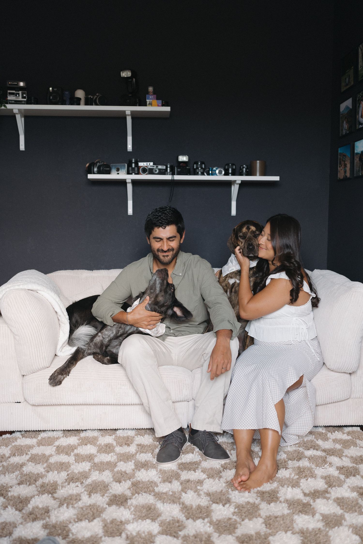 Lifestyle portrait of couple relaxing on white couch with their gray cat.