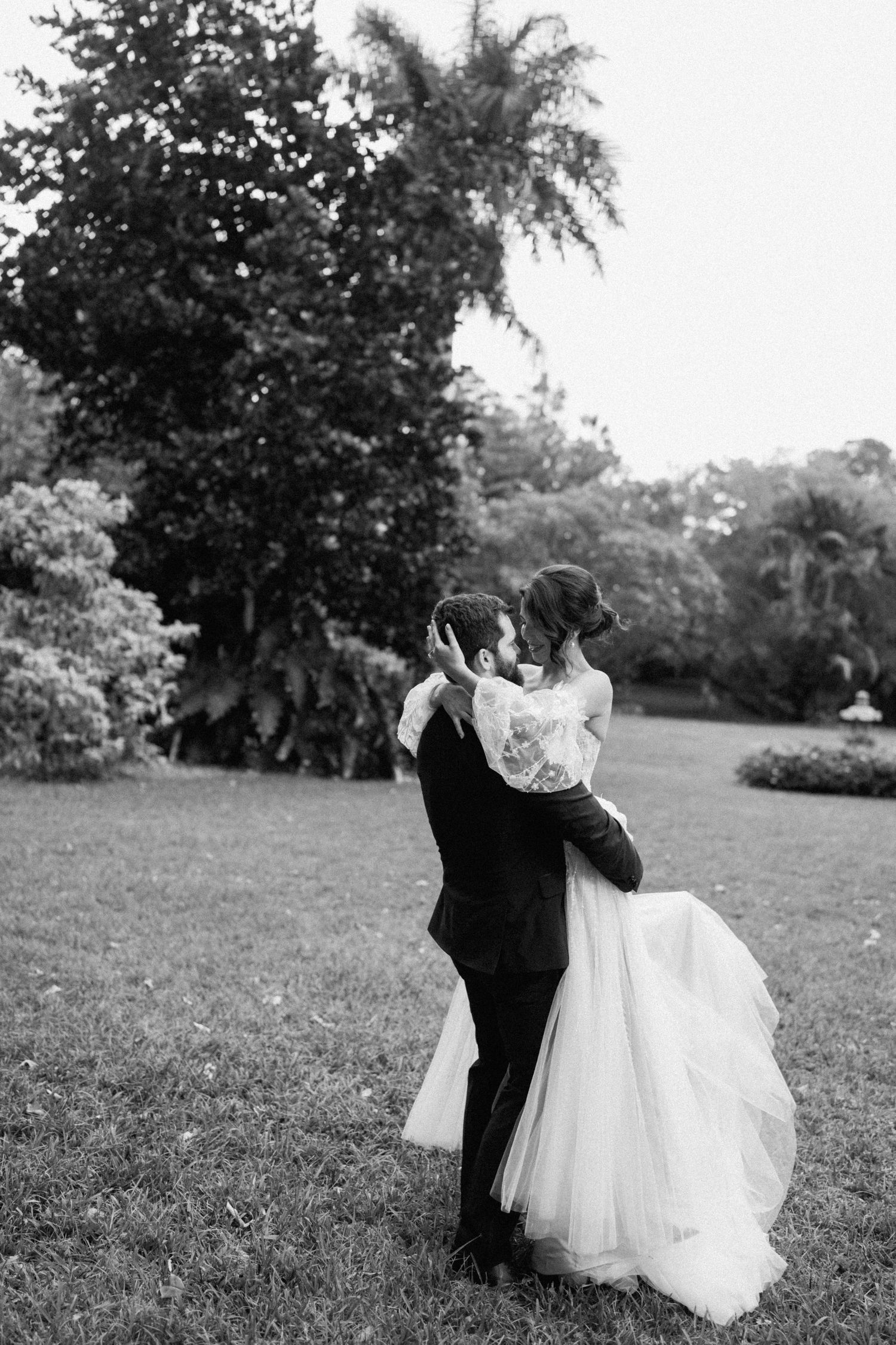 A romantic black and white sequence shows a couple dancing and spinning in a park setting with the bride's white dress flowing.