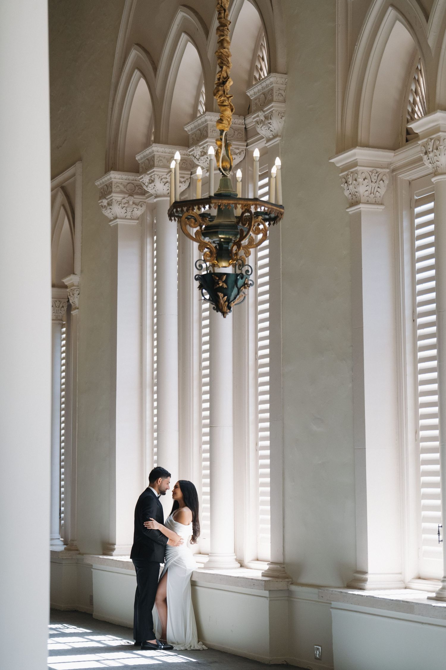 A beautiful architectural interior featuring tall windows, elegant columns, and ornate chandeliers.