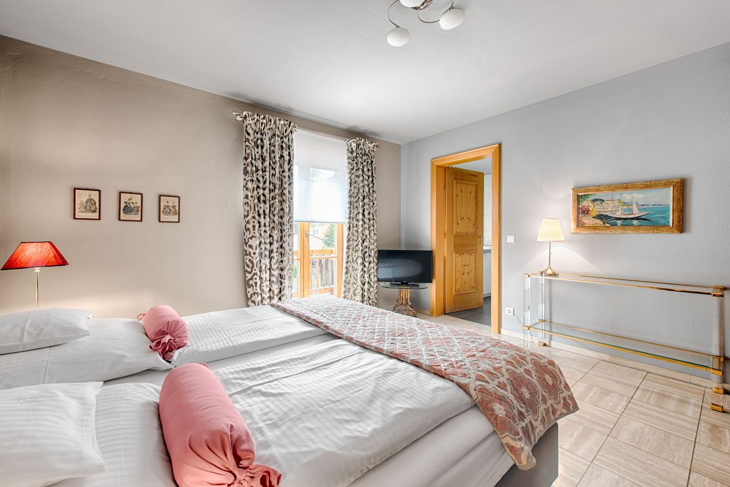 Bright modern bedroom with twin beds, floral curtains, wooden furniture and coral accent pillows against light grey walls.