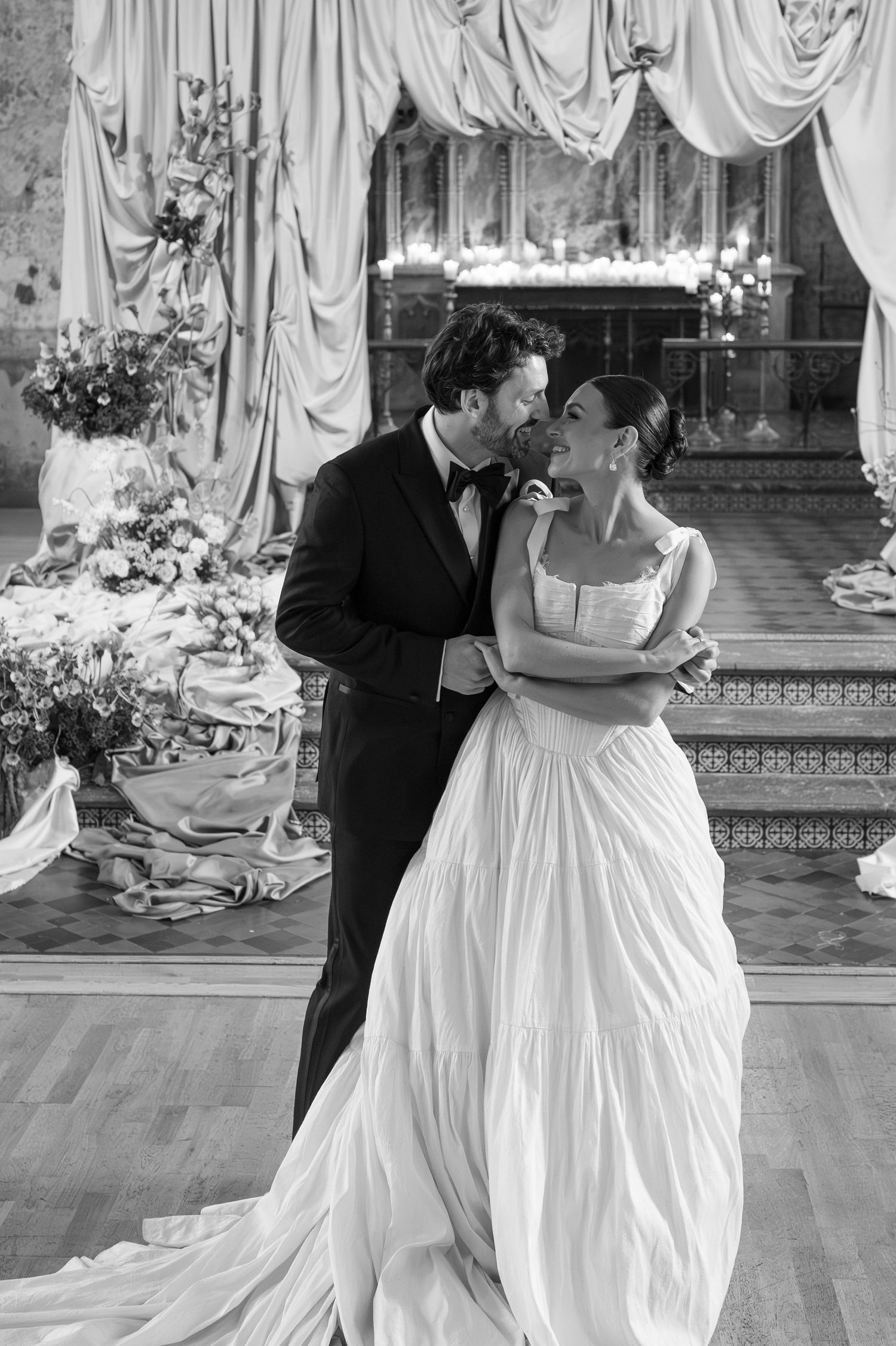 A bride and groom dance elegantly in wedding attire, with the bride in a flowing white gown twirling gracefully across the ballroom floor.