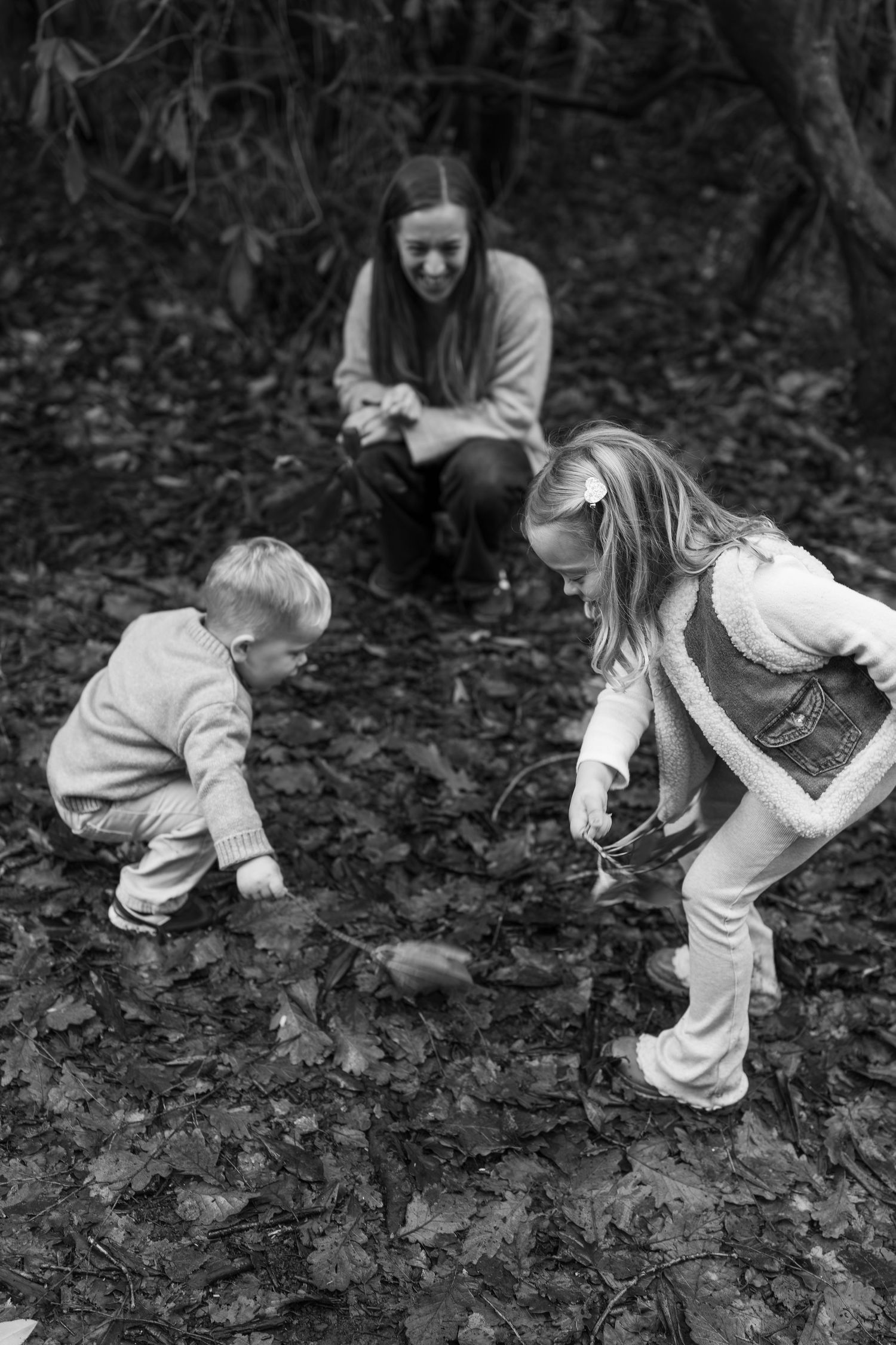 Black and white photos showing exploration of fallen leaves on a forest floor.