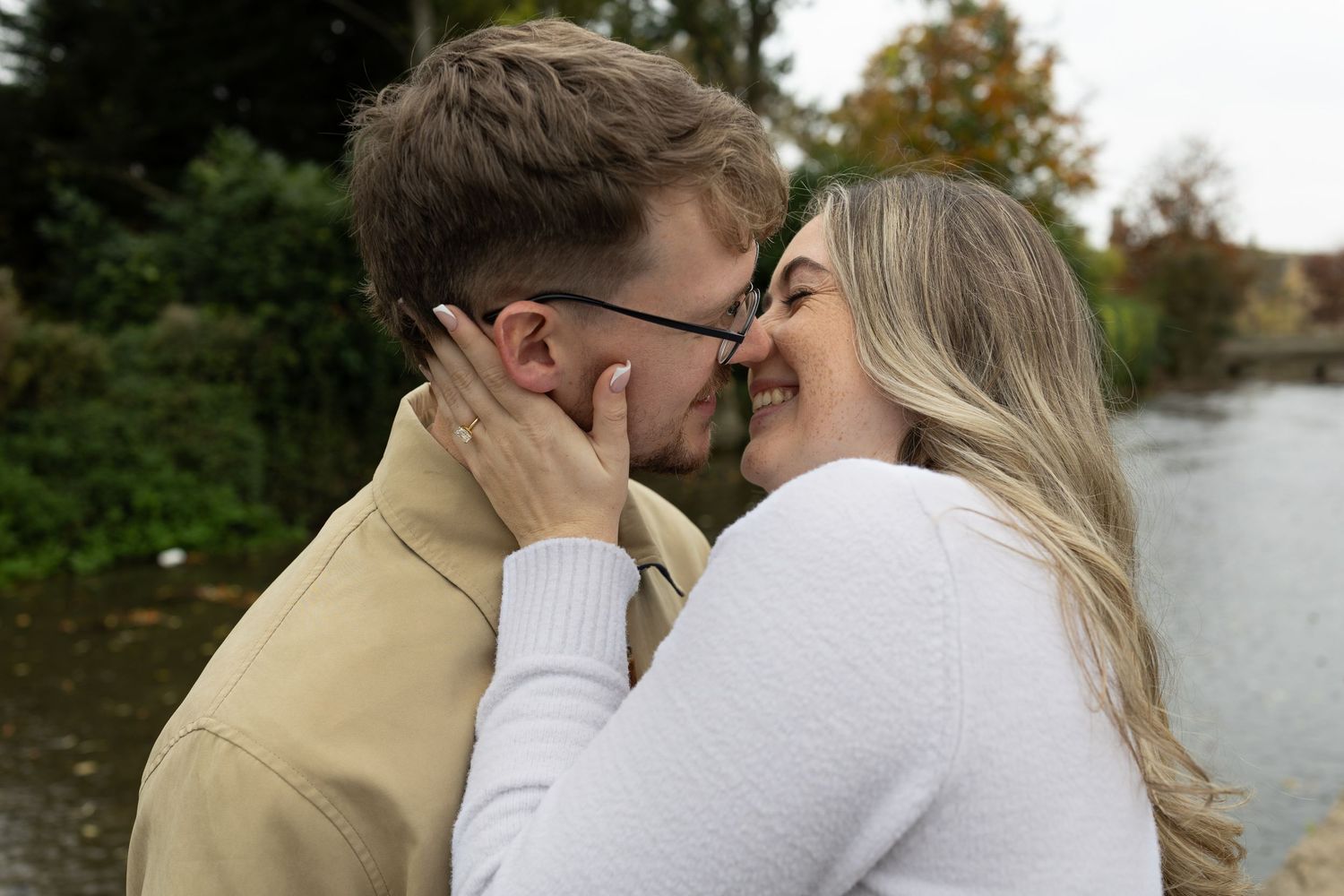 A tender moment shared between two people near a waterway.