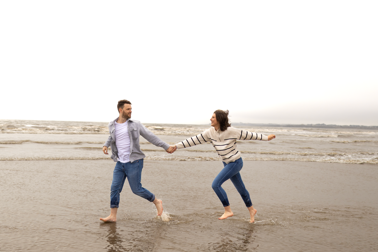 Couple playing and dancing together on a peaceful beach.
