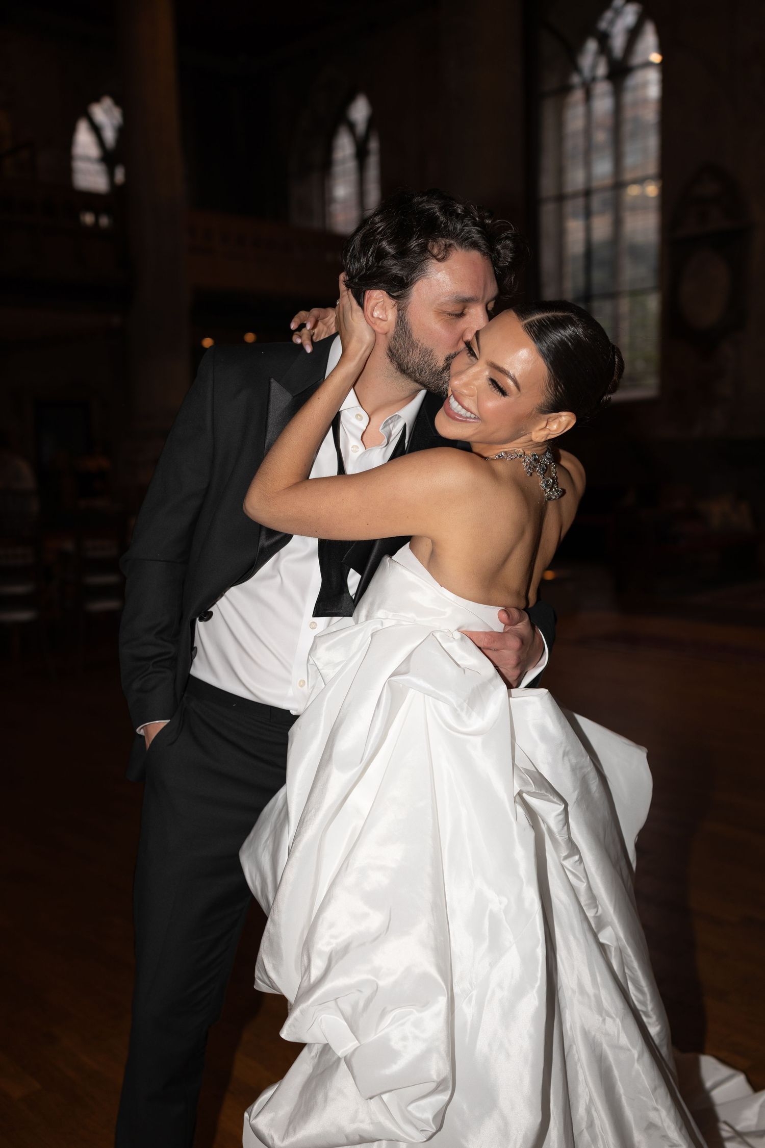A couple dances together in formal attire, with the person in white spinning gracefully during their dance.