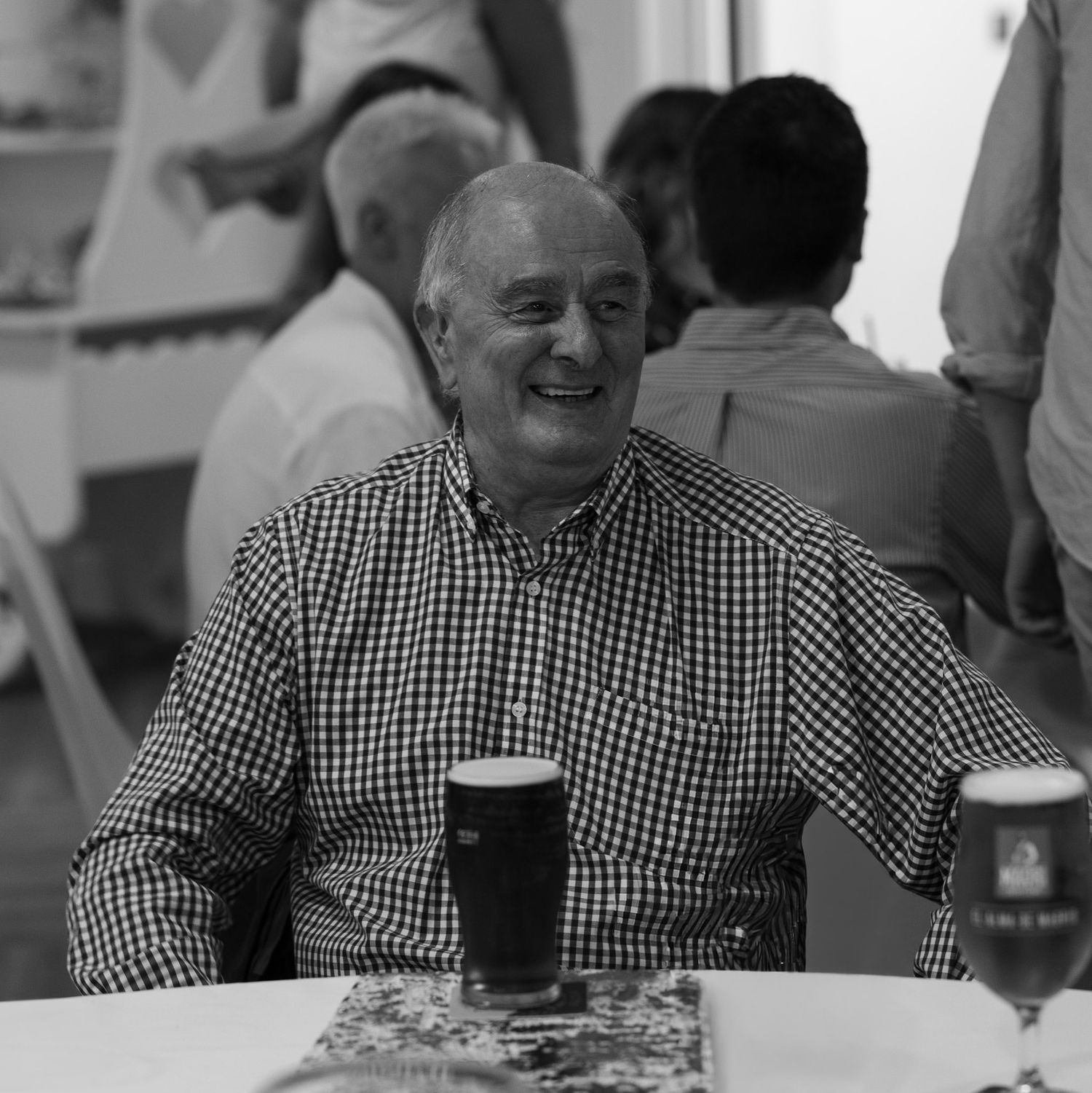 Black and white candid photos of guest enjoying wedding reception.