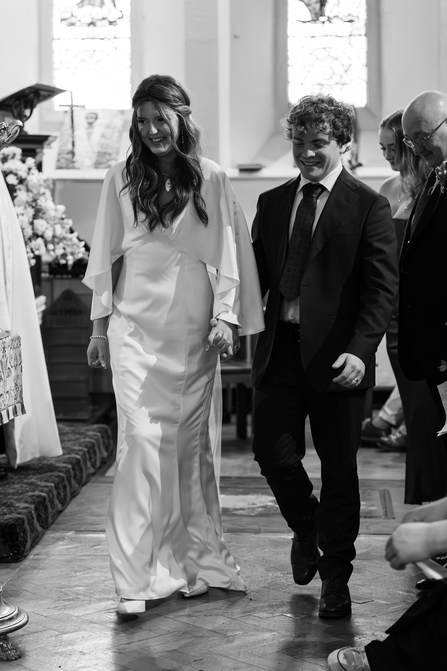 A couple walks down the church aisle after their wedding ceremony.