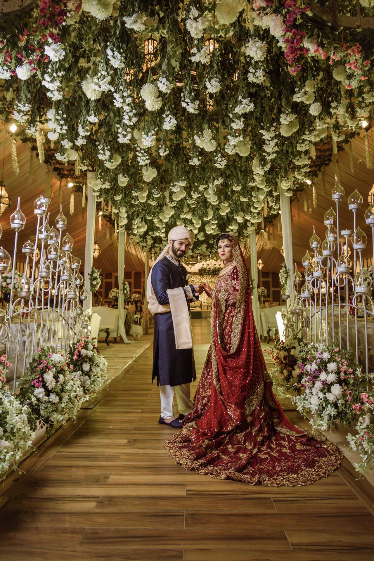 Pakistani bride posing against the intricately carved walls of Badshahi Mosque, symbolizing cultural heritage.