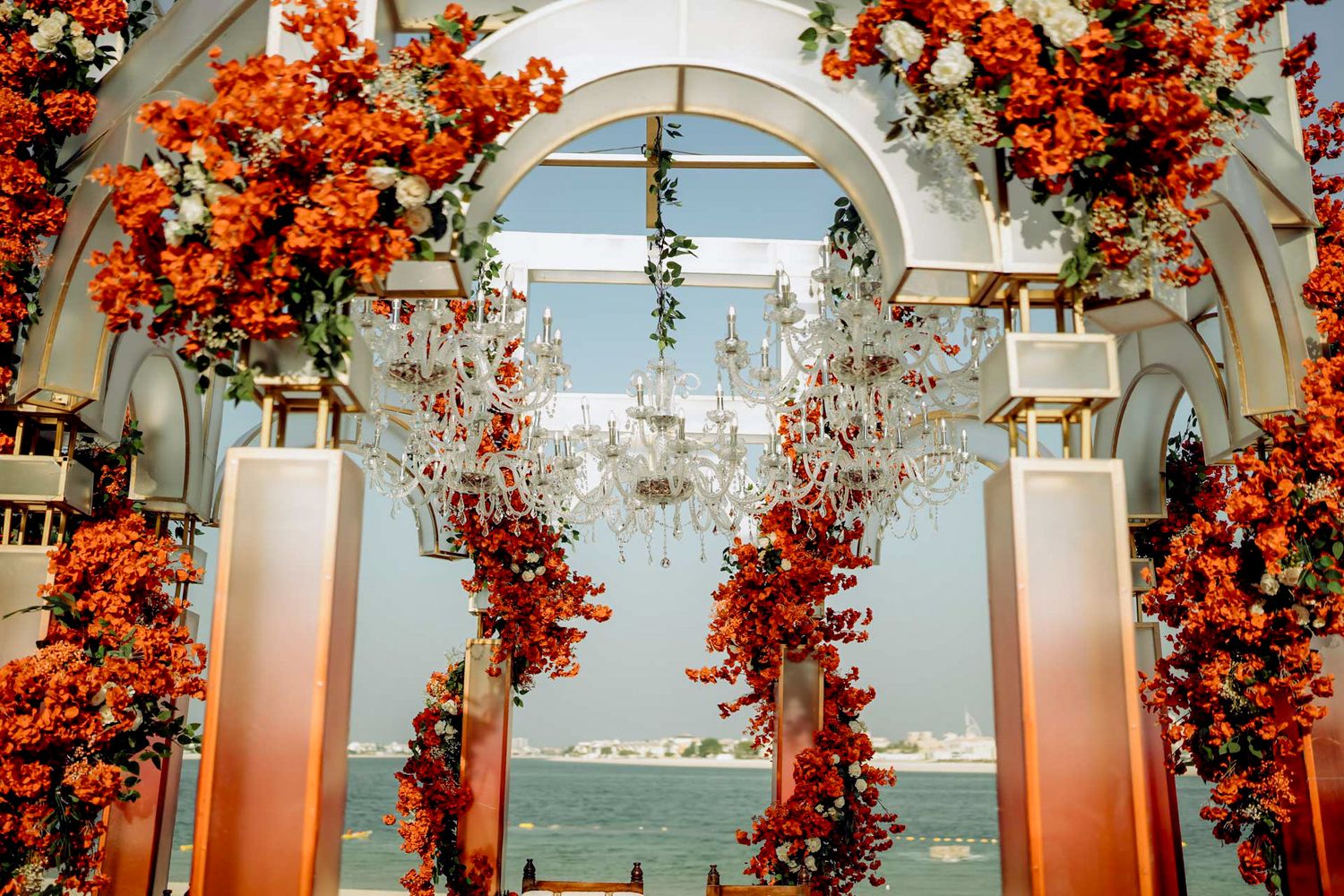 fill with red ross tones in the mandap stage designed to elevate the ambiance of a high-end multicultural wedding celebration.