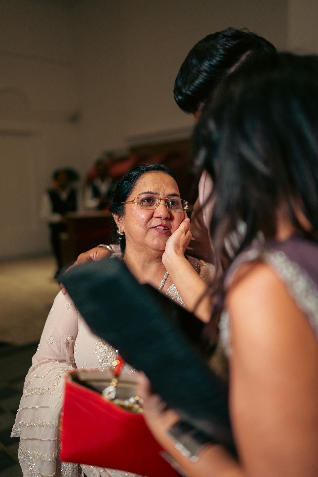 Heartfelt moment captured: mother whispering a dua into the bride's ear, reflecting the deep love and tradition of South Asian weddings.