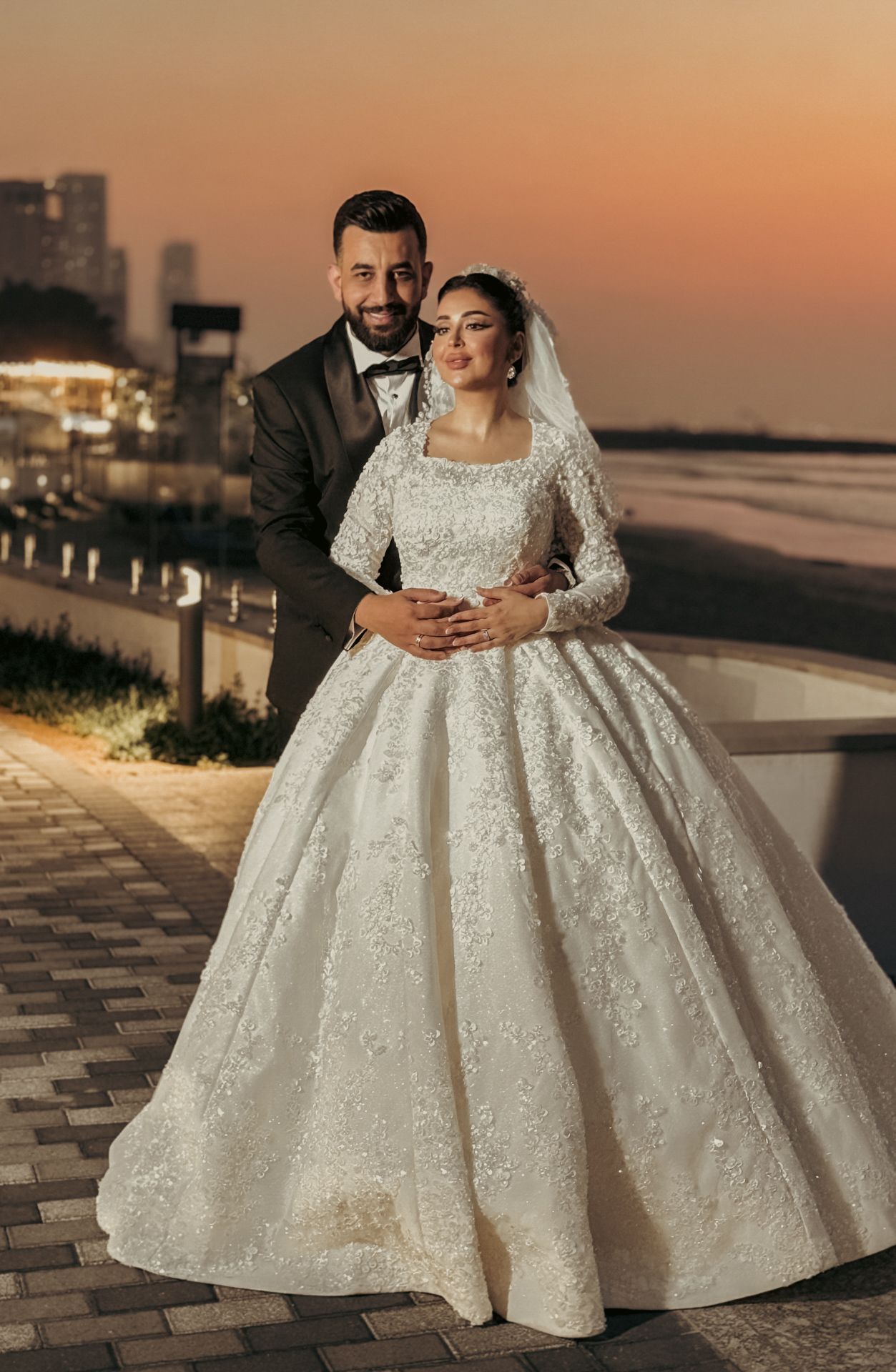 Emotional moment from a Dubai wedding where the groom lifts the bride during their first dance under chandeliers.