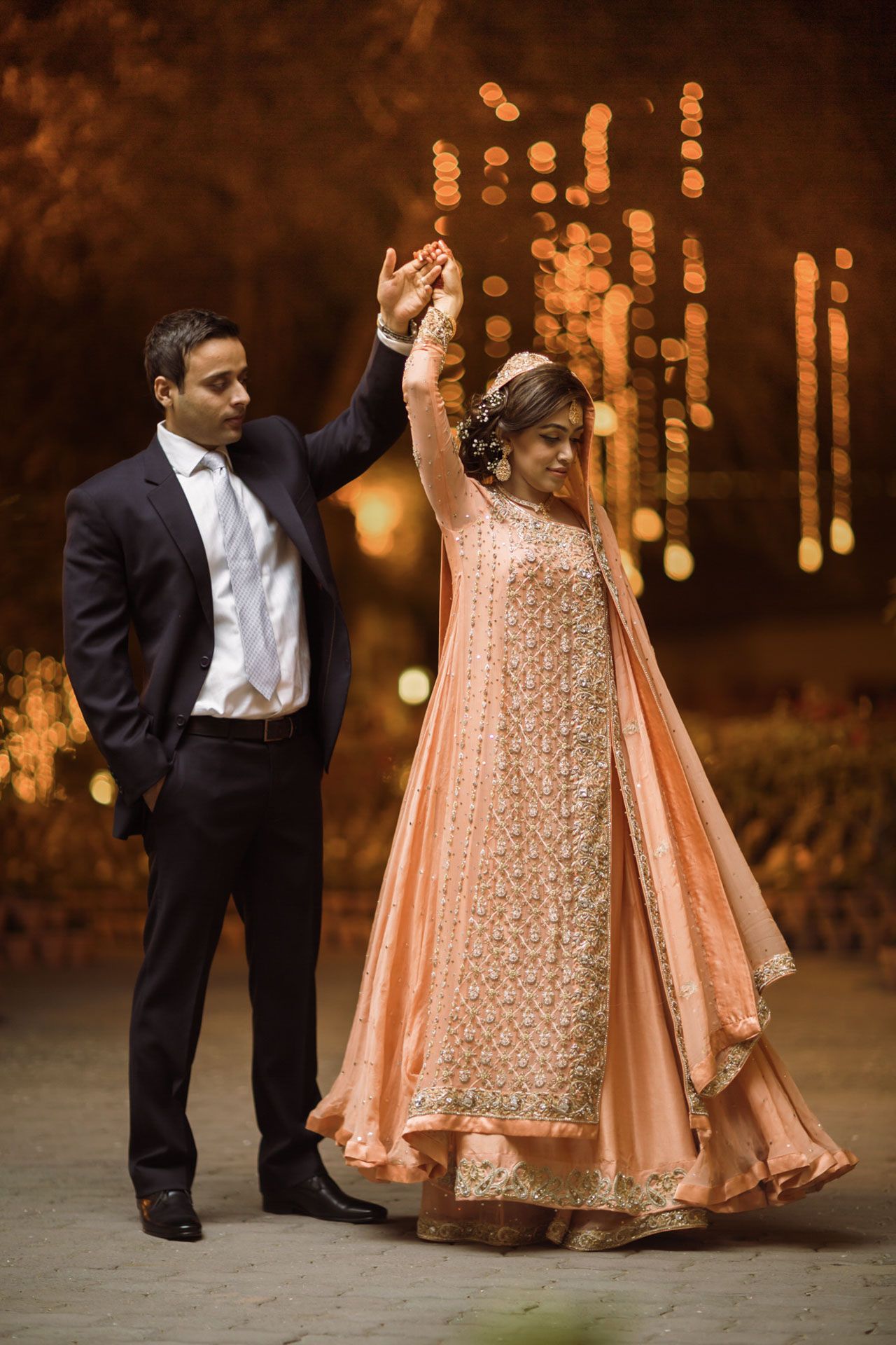 Pakistani couple walking hand in hand through the heritage gardens of Mohatta Palace, Karachi during their wedding shoot.