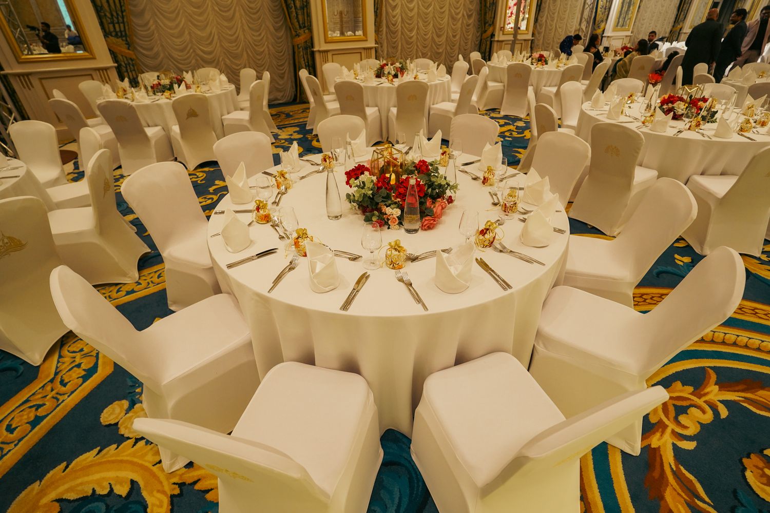 A round table with roses designed to elevate the ambiance of a high-end Indian and Pakistani wedding celebration.