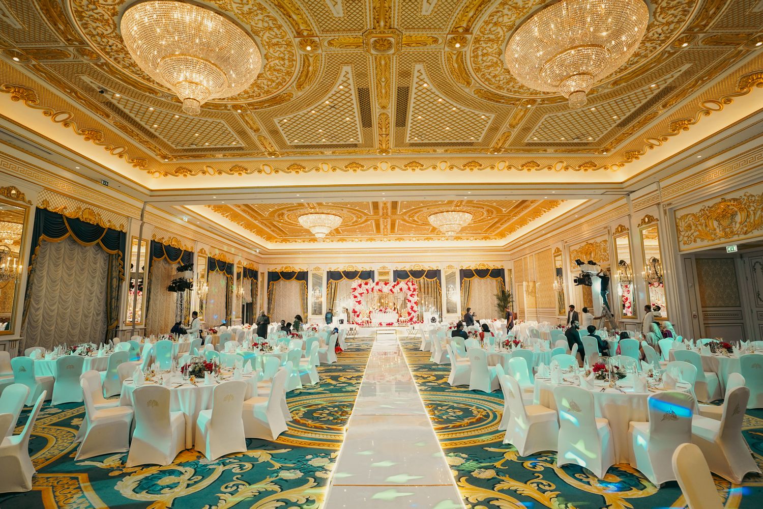 Hanging marigold wall with mehndi backdrop designed to elevate the ambiance of a high-end multicultural wedding celebration.