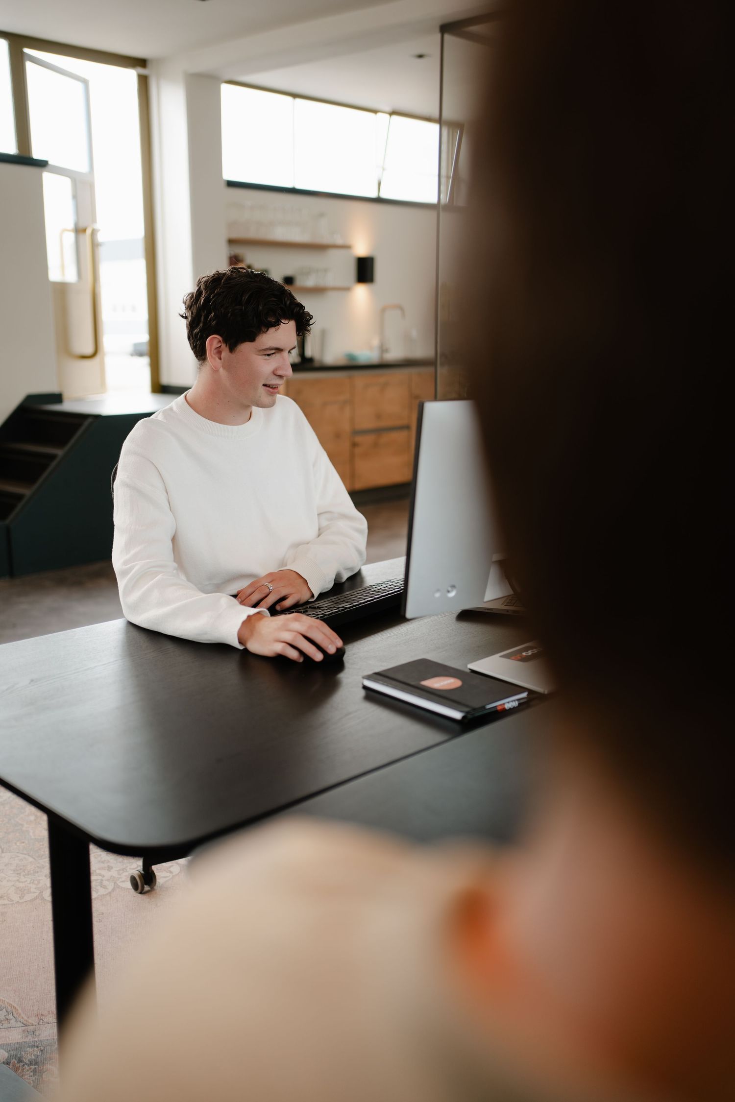 Medewerker achter laptop tijdens brandingshoot in Den Haag