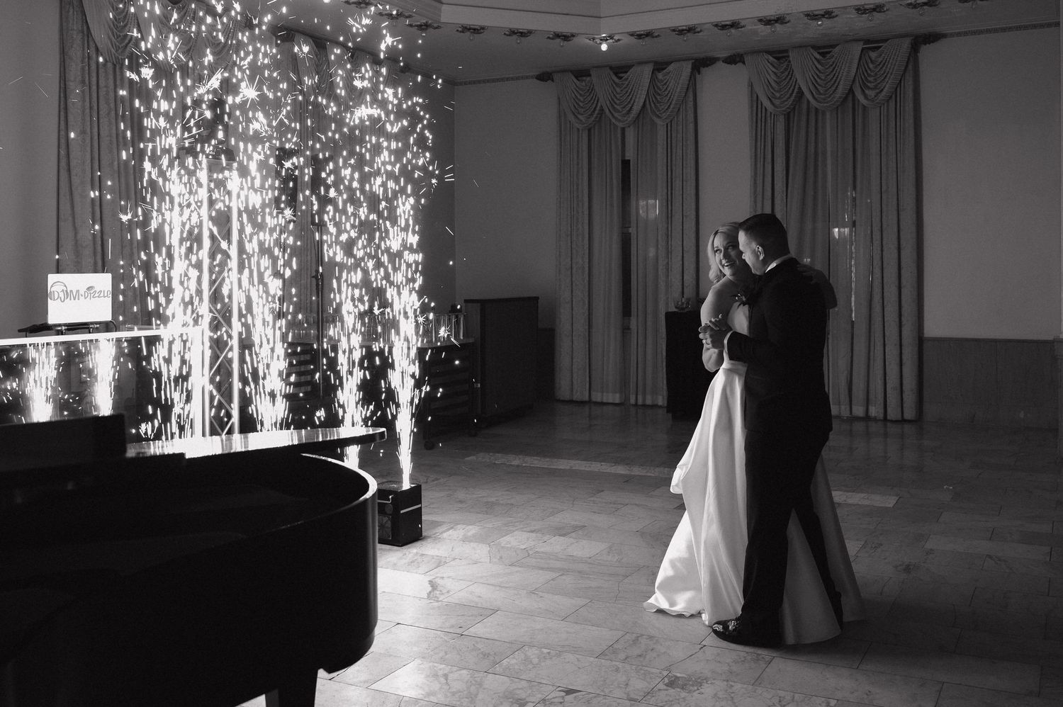 Couple sharing their first dance at a wedding reception with dramatic sparkler fountain display behind them. First Dance Photo inspo.