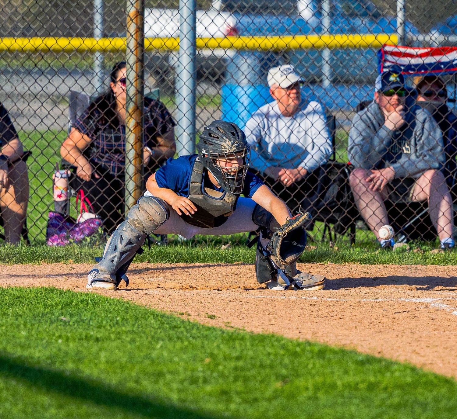 Close-up panoramic view of baseball players on field with dugout and spectators in background during game.