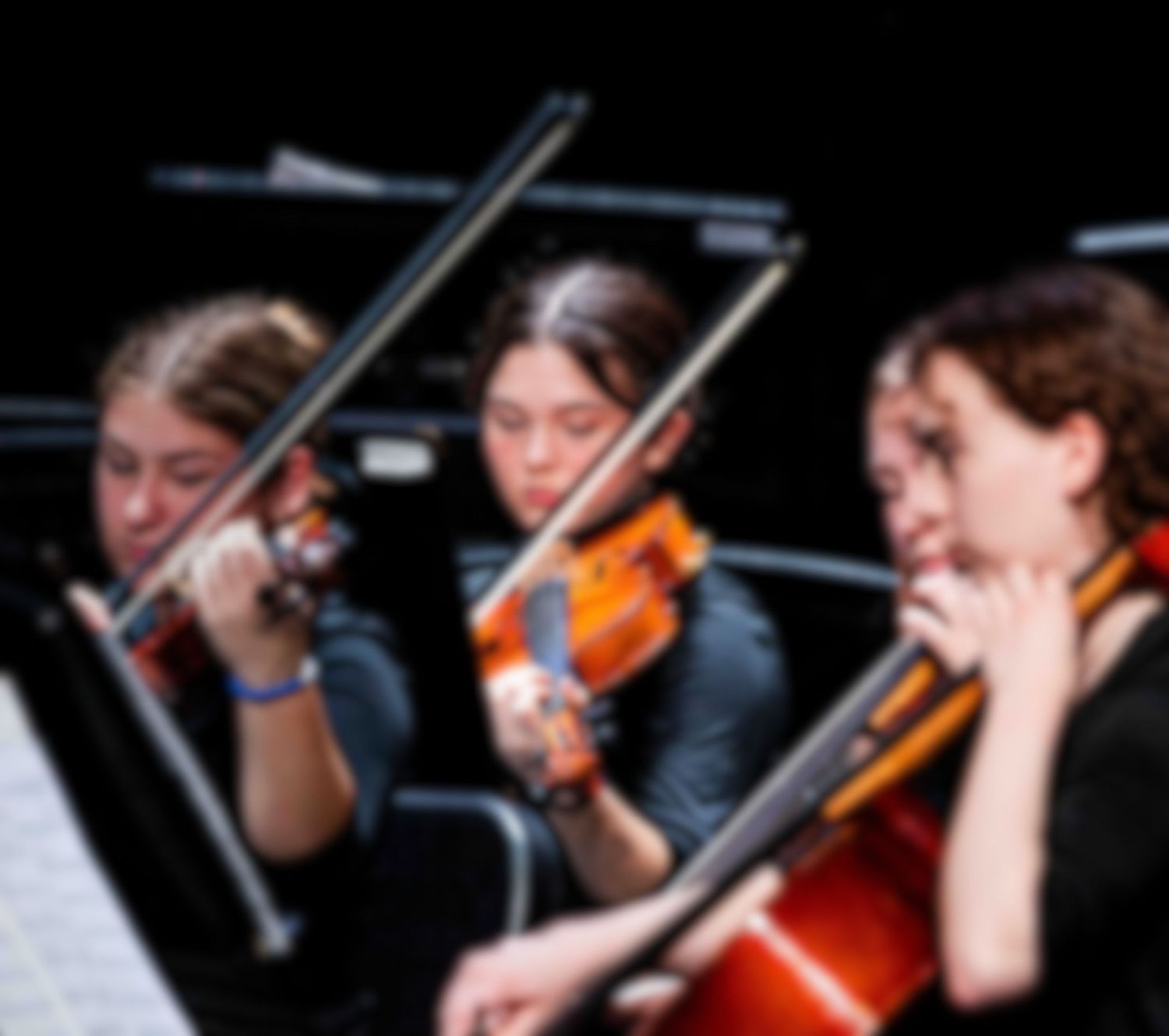 Musicians perform in an orchestra section with string instruments during a classical performance.