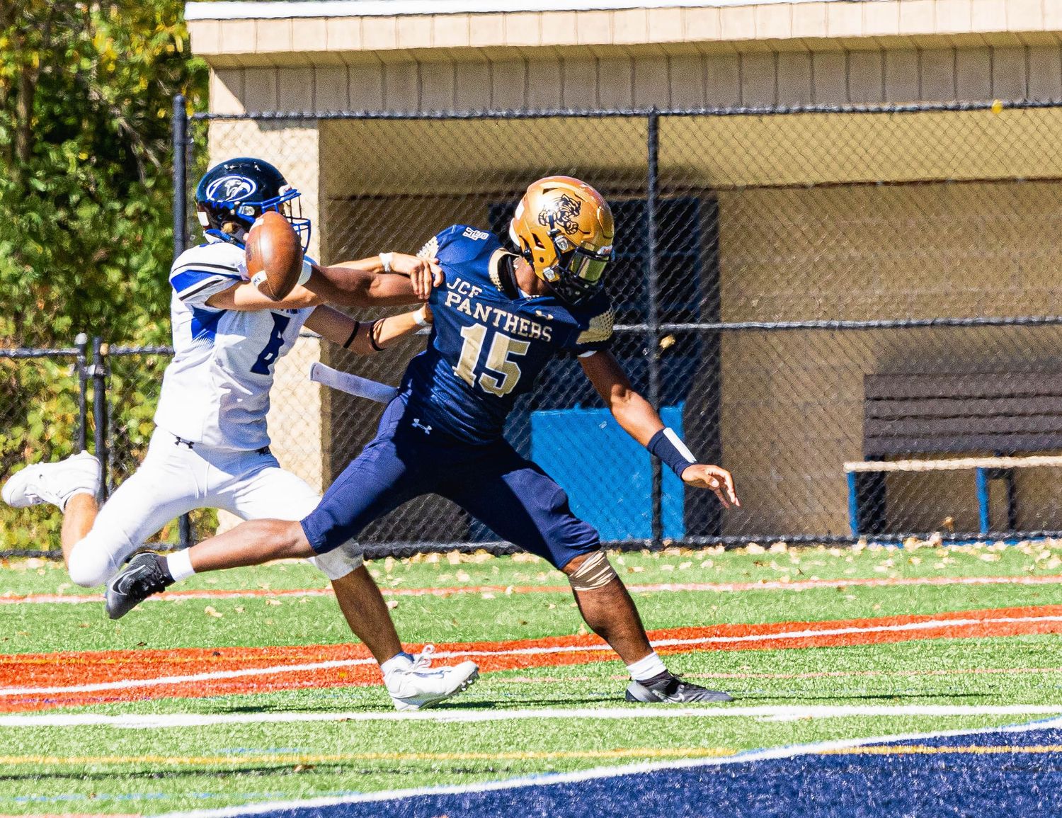 Football player #15 in navy Panthers uniform evades defender during college football game on turf field.