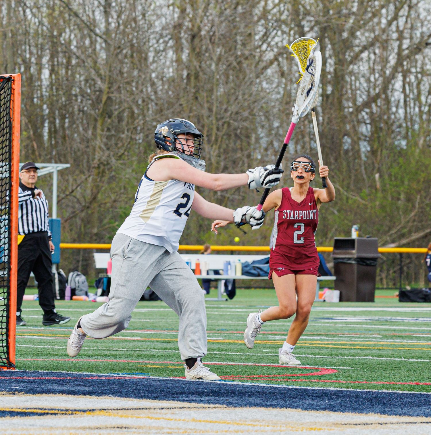 Female lacrosse player shoots on goal during a competitive girls lacrosse game against Starpoint.