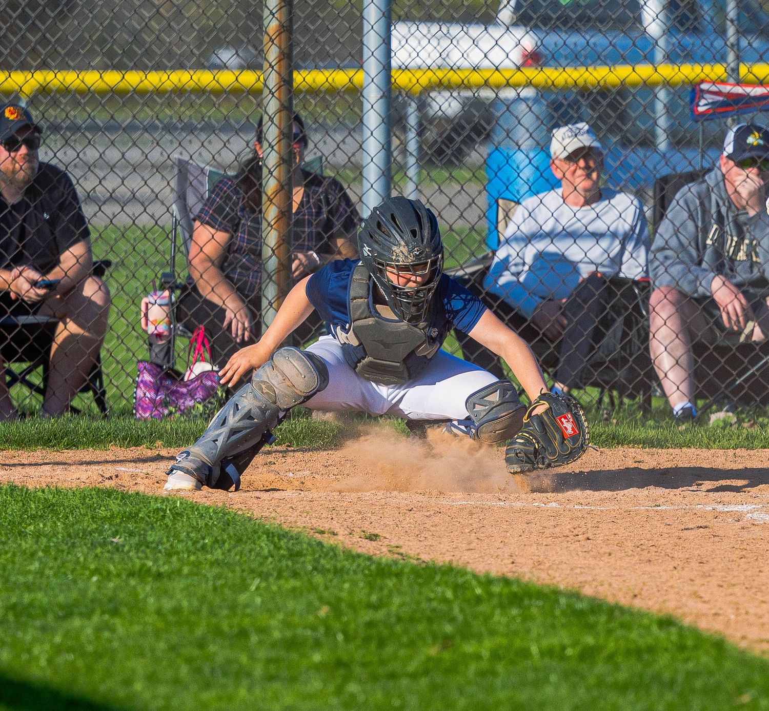 Multi-panel sequence showing a baseball or softball player sliding into home plate during a game on a dirt field.