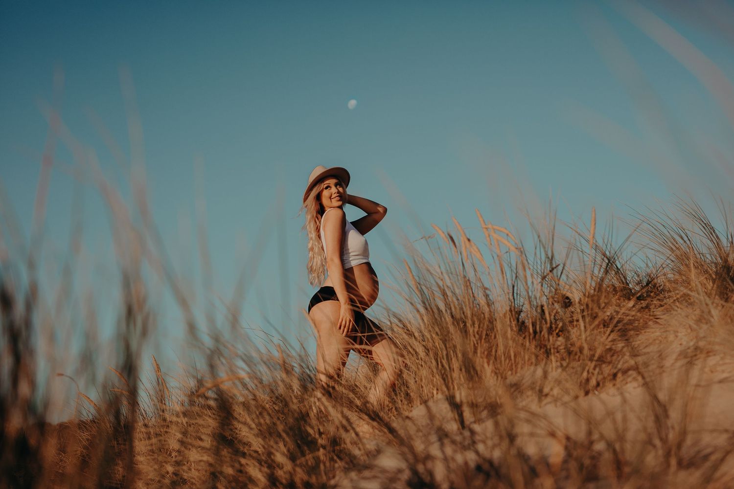 Pregnant woman standing in sand dunes in Adelaide, South Australia