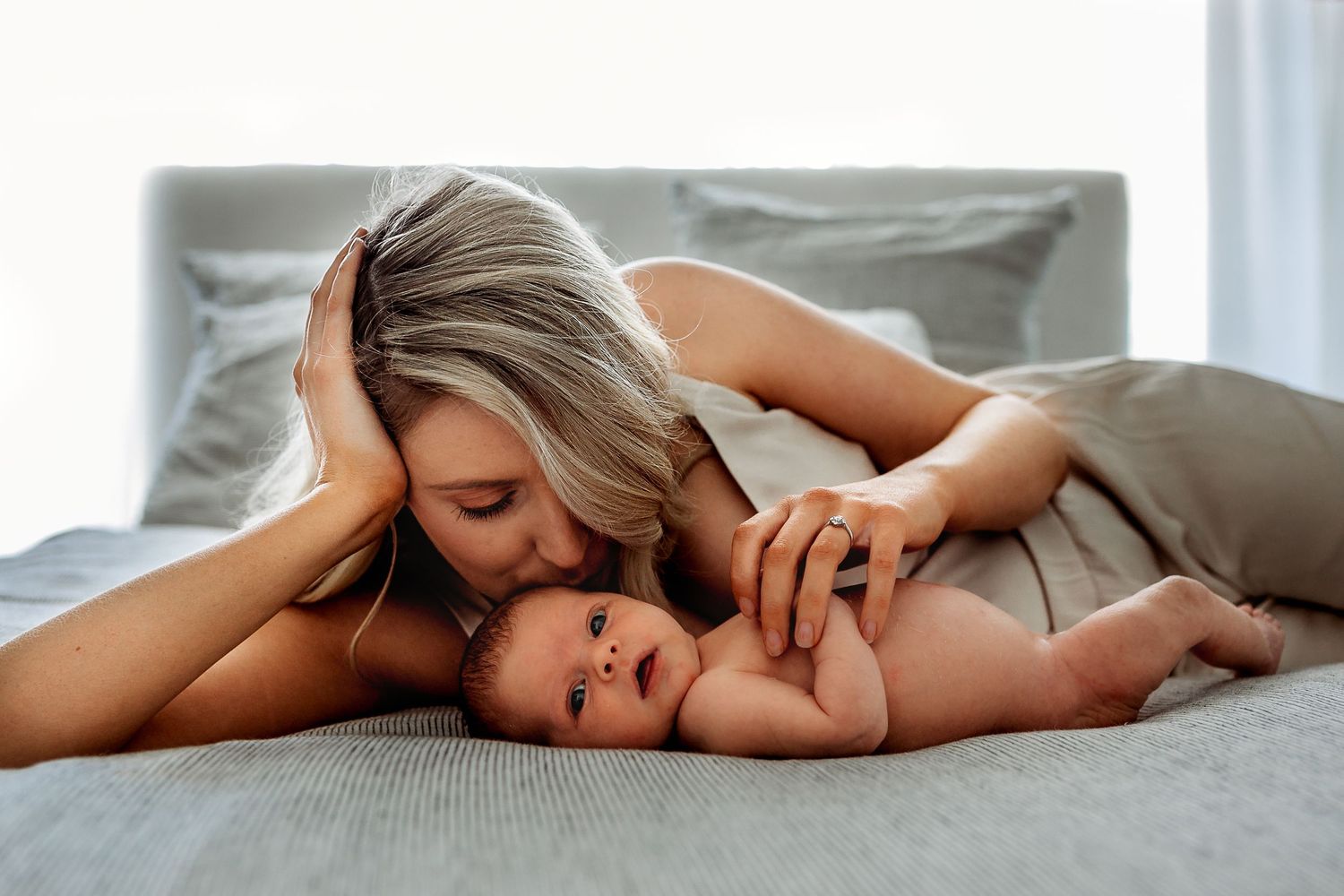 Mum laying on a bed kissing her newborn baby in Adelaide, South Australia