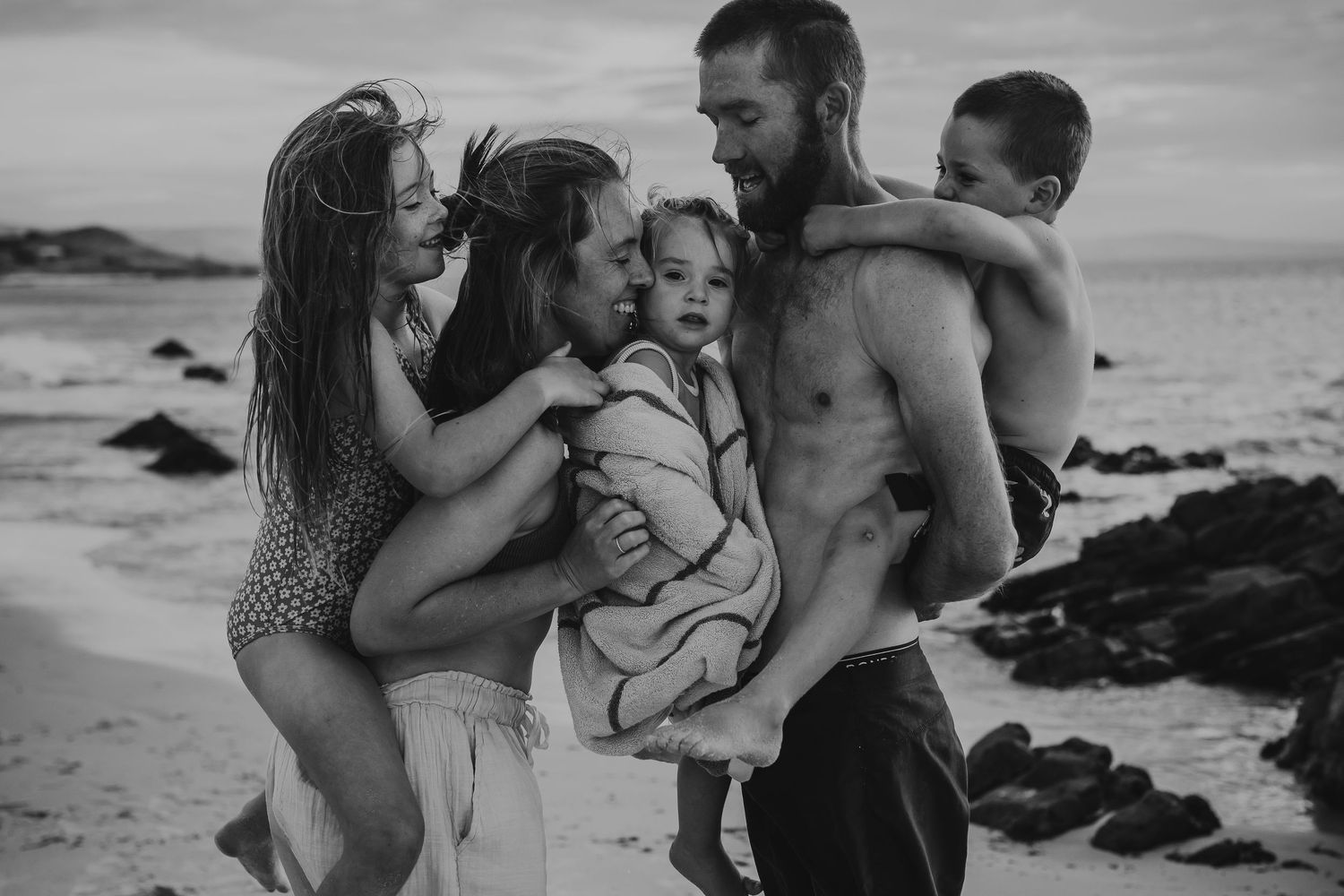 Family cuddling on the beach, fun family photo shoot in Adelaide, South Australia