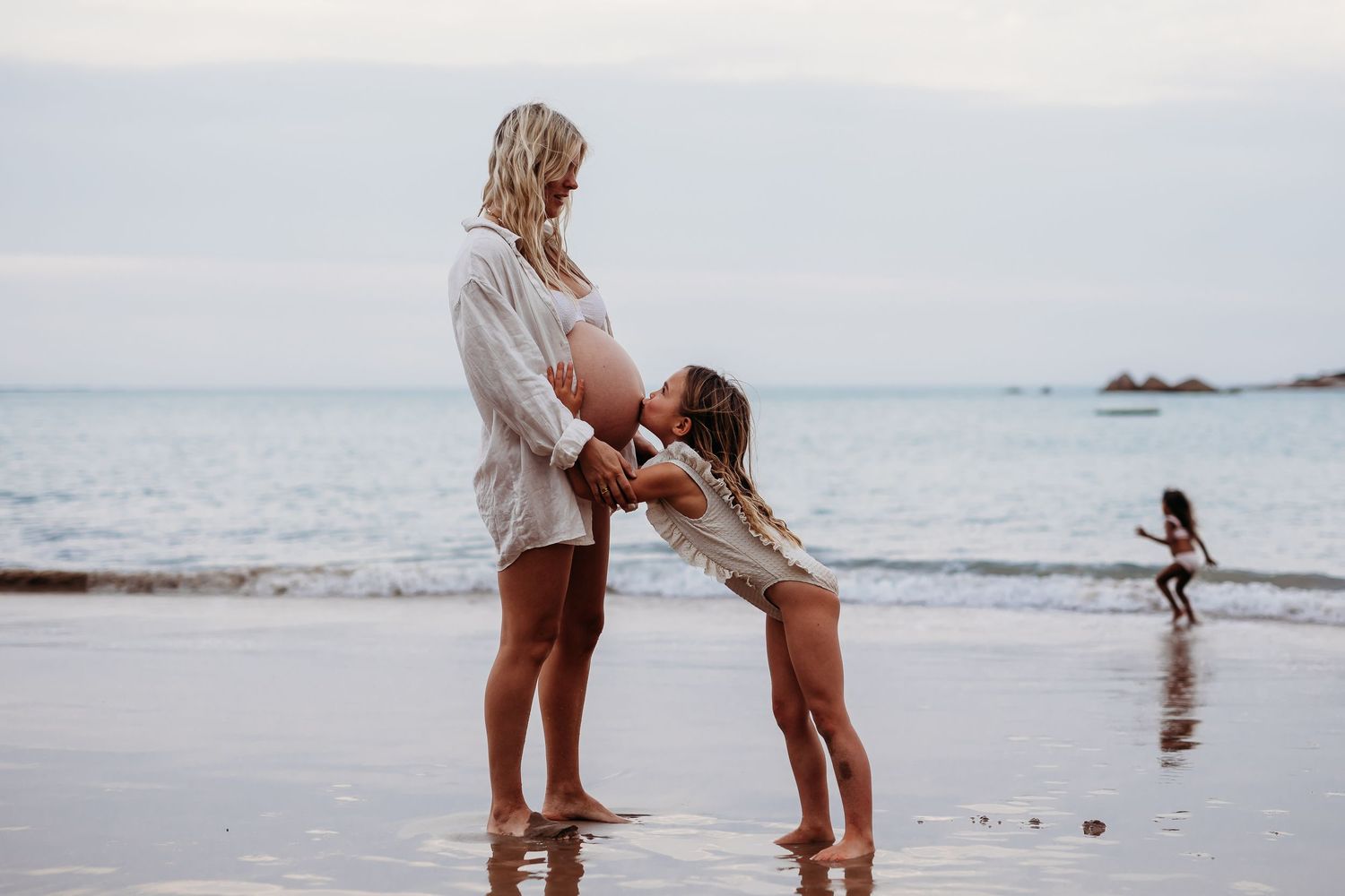 Sweet image of young child kissing mother’s baby bump – Raised by Water Photography, South Australia