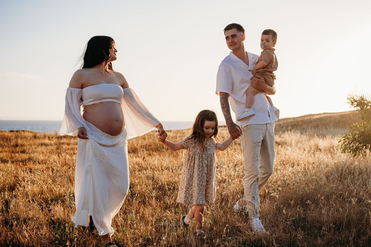 Family walking through a golden field at sunset in Adelaide, South Australia – Raised by Water Photography