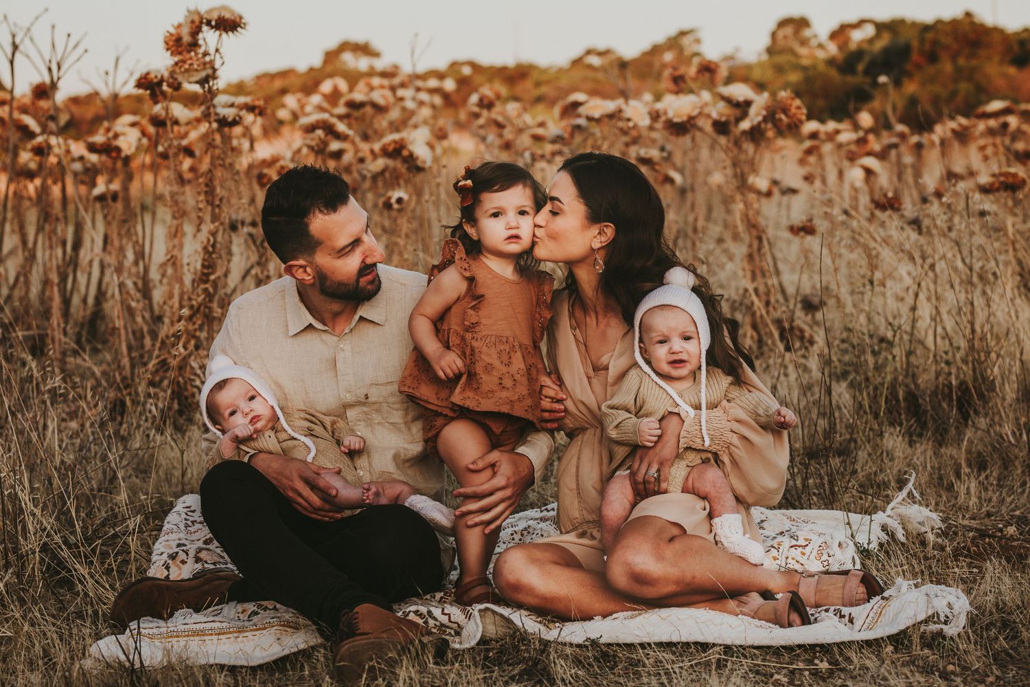 Family sitting in golden field. Adelaide family and newborn photographer