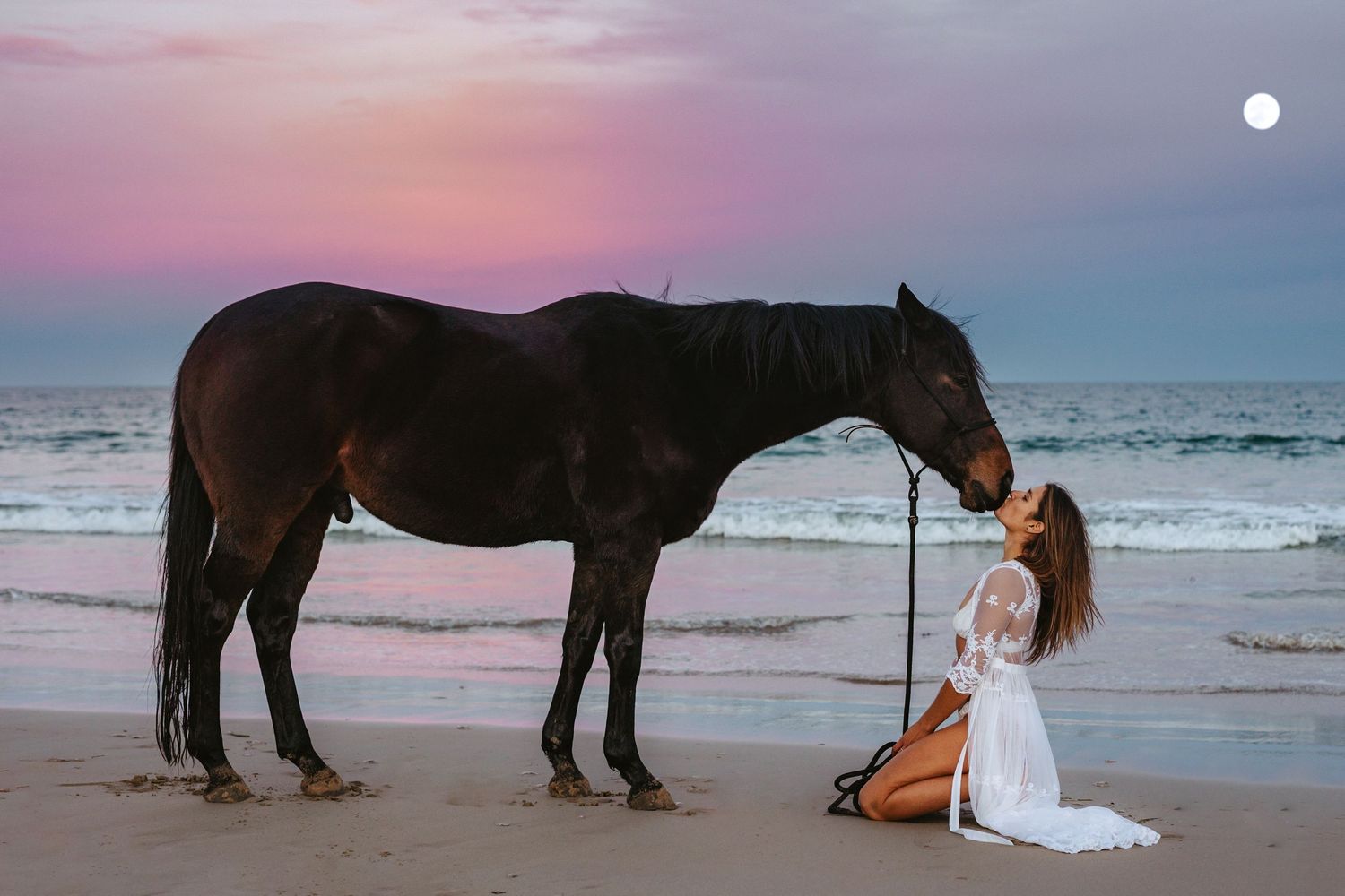 Ethereal beach photo of woman with horse beneath a full moon and pastel pink sky in Adelaide, South Australia