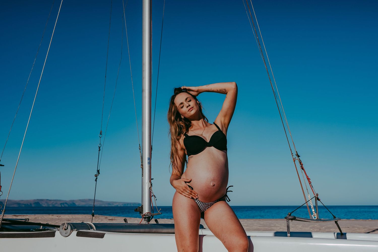 Pregnant lady leaning against a boat near the ocean. Adelaide maternity photographer - Raised by Water Photography