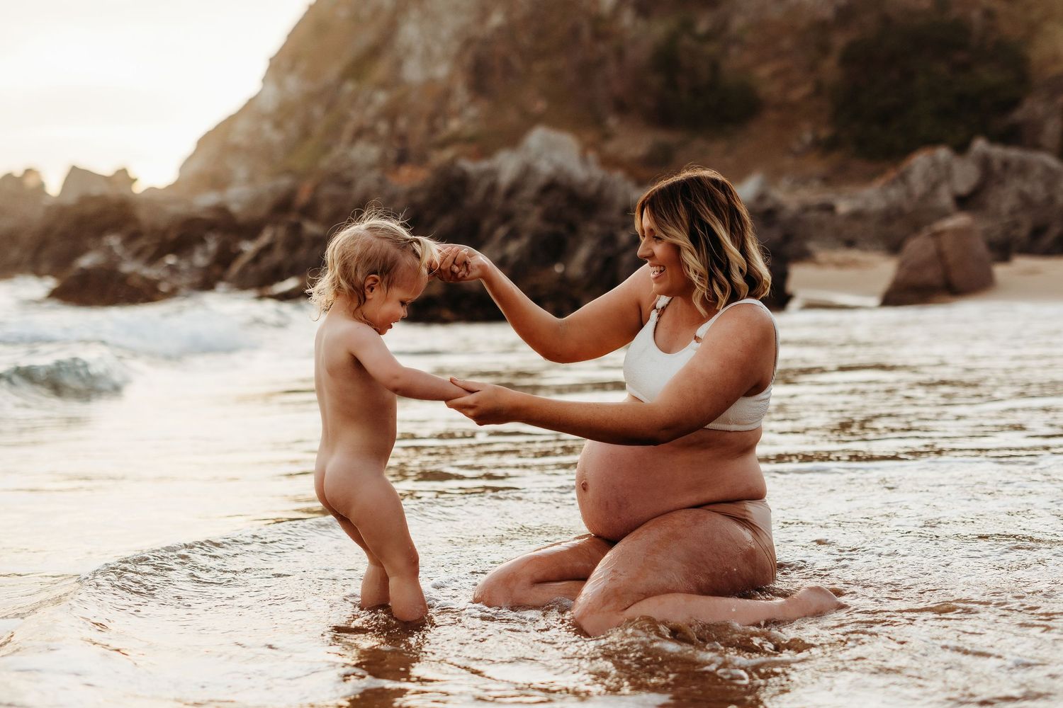 Mum and toddler holding hands while standing in shallow ocean water – Raised by Water Photography, Adelaide