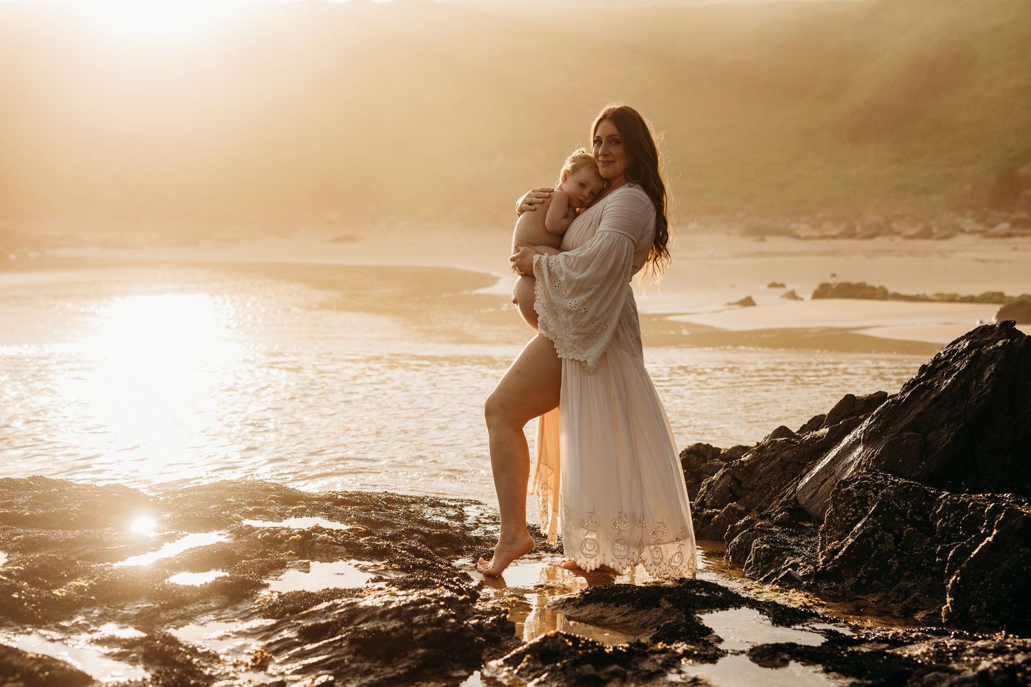 Pregnant mum holding child on Adelaide beach during maternity session – Raised by Water Photography