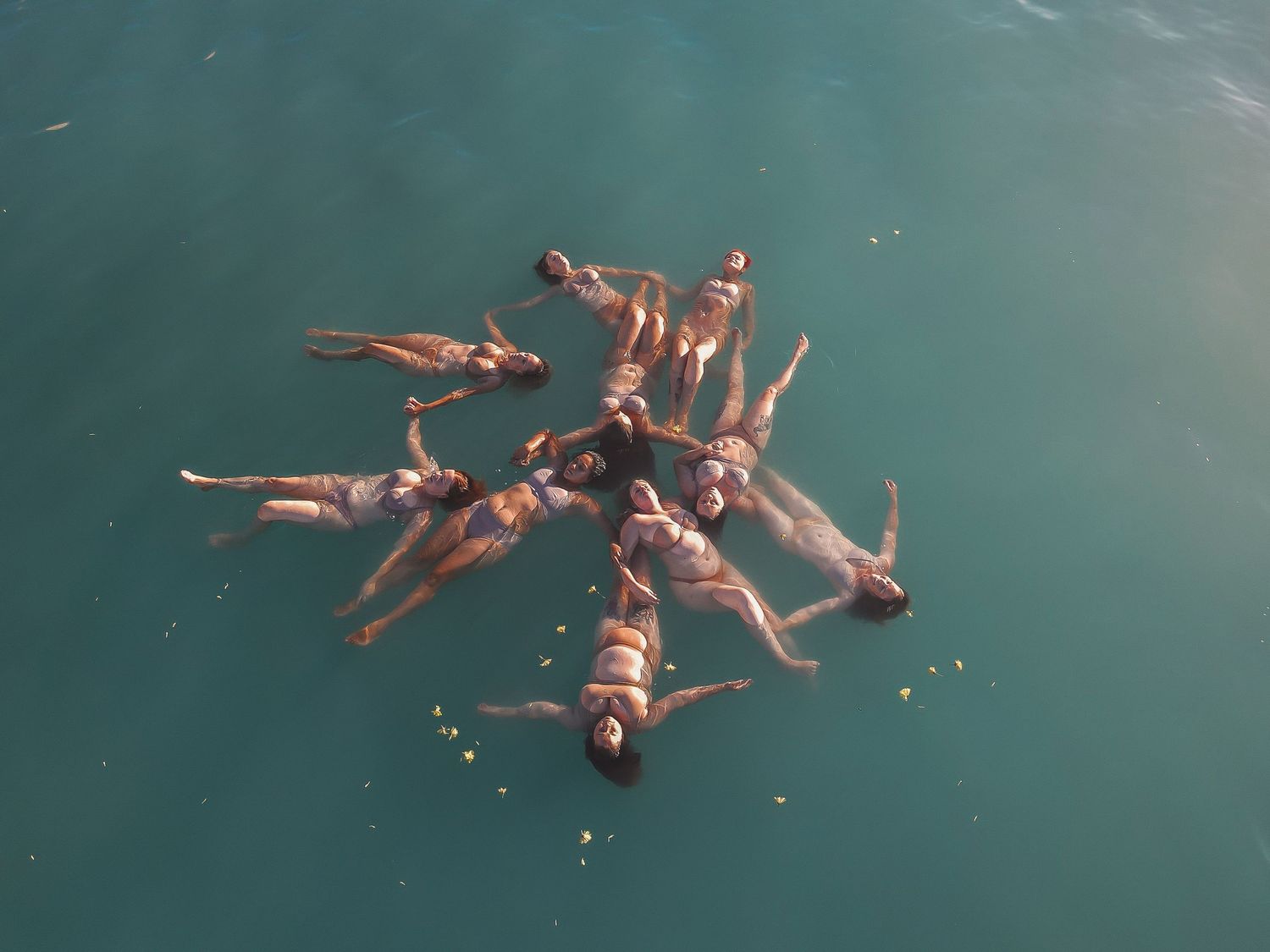 Aerial view of women floating together in shallow ocean water – Adelaide photography