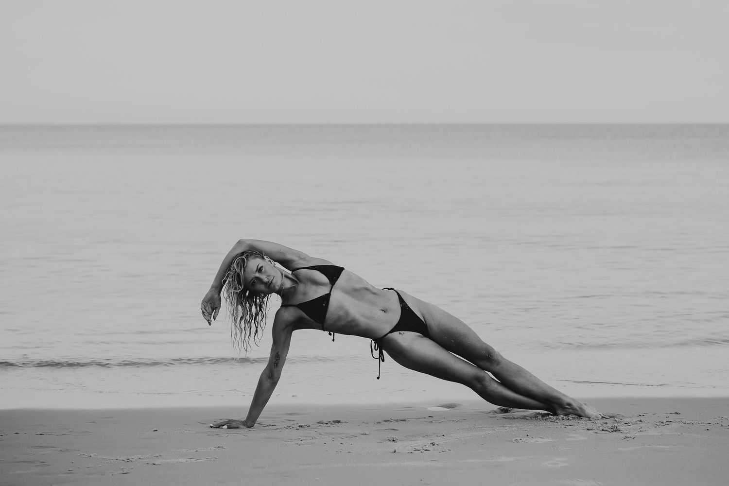Woman lying on her side on sandy beach during golden hour – Adelaide beach photography