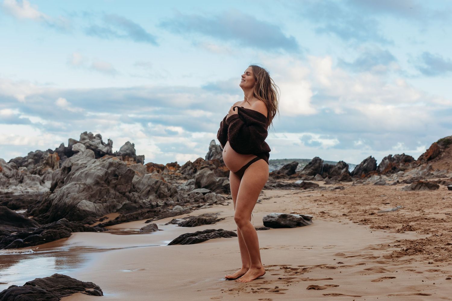 Lady standing on beach embracing pregnant belly Adelaide, South Australia