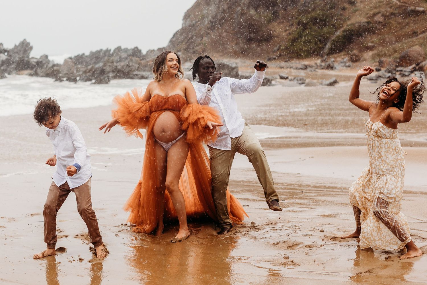 Playful family embracing rainy beach weather in Adelaide, South Australia, connection and laughter