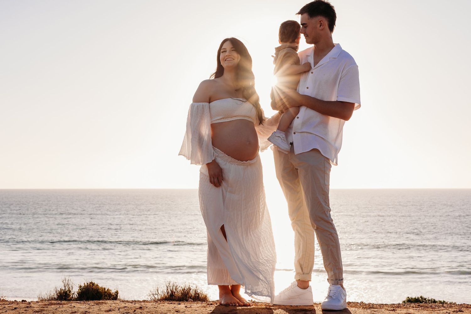 Family standing on cliff beachside with golden light.  Adelaide family and maternity photographer