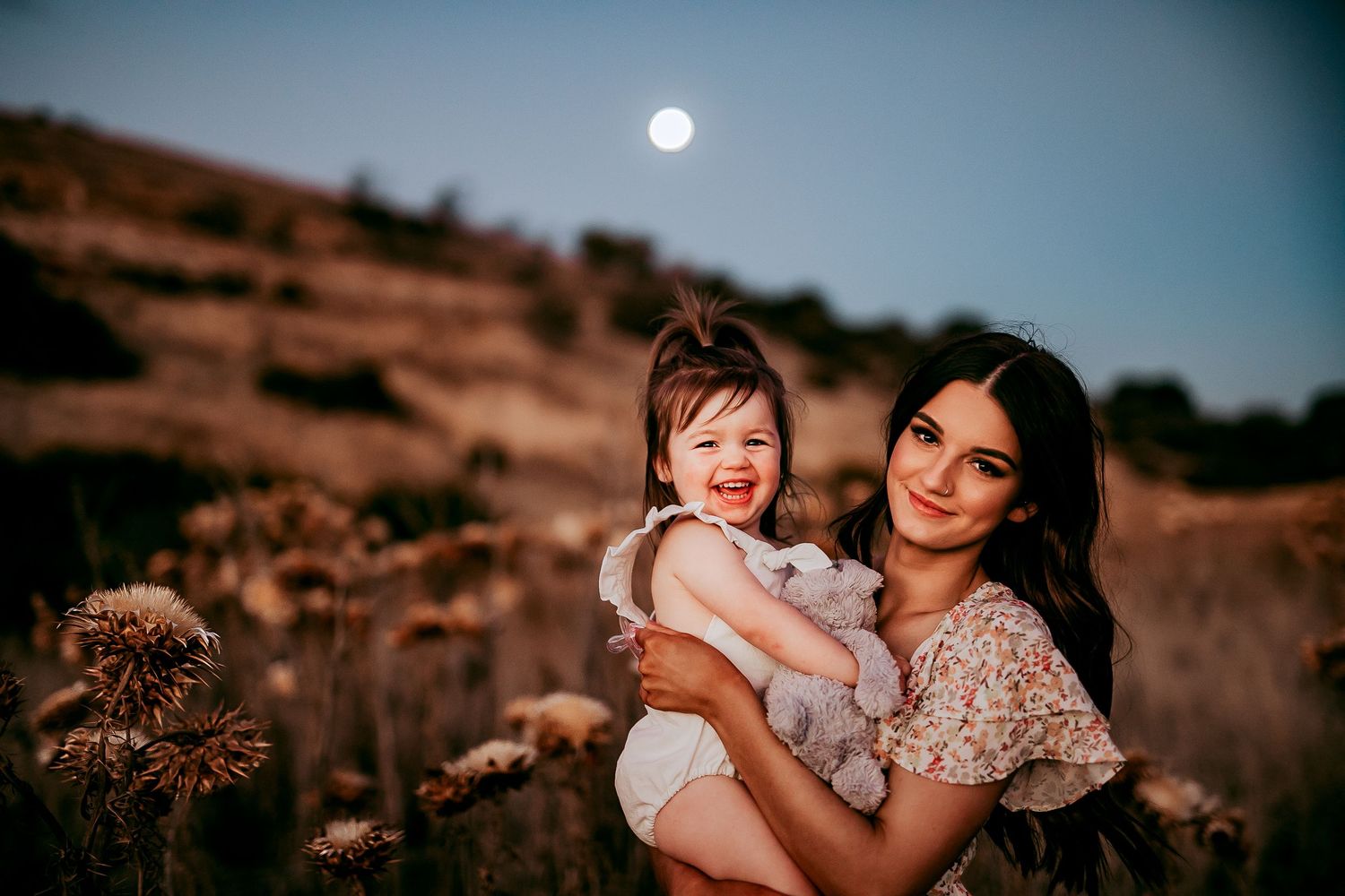 Mum and child standing in golden field at sunset with full moon rising behind – Raised by Water Photography, Adelaide