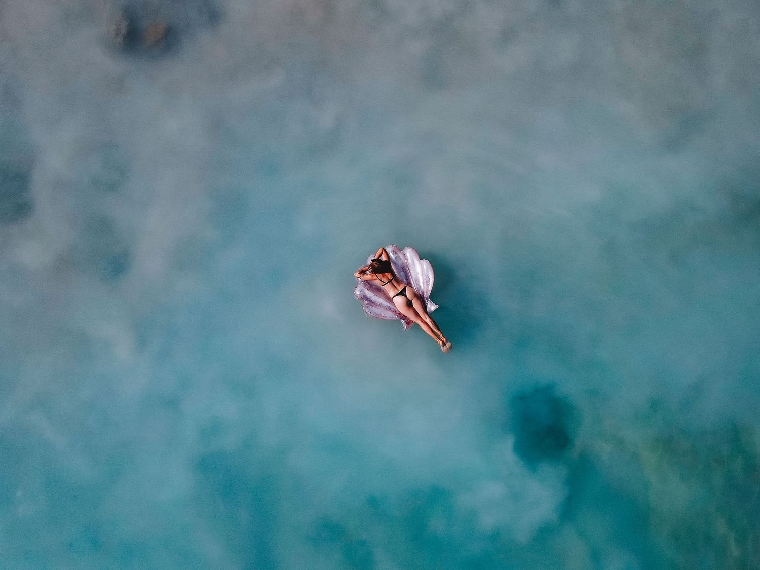 Dreamy ocean scene with woman floating on giant shell, surrounded by calm South Australian waters