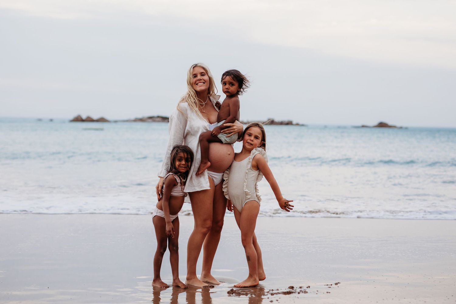 Warm and intimate beach family portrait with Mum and children embracing – Raised by Water Photography