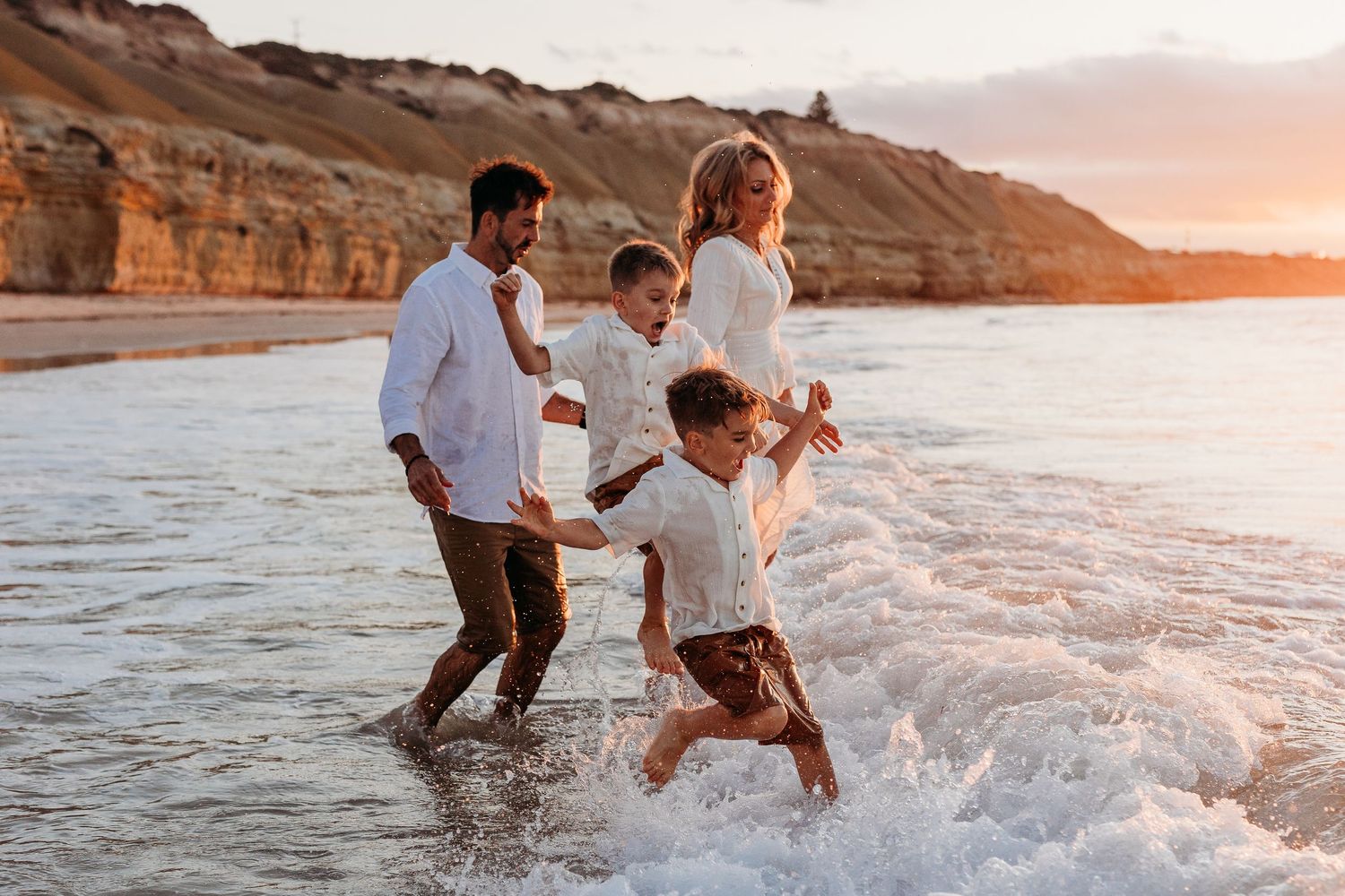 Family running into the ocean at sunset in Adelaide, South Australia – Raised by Water Photography