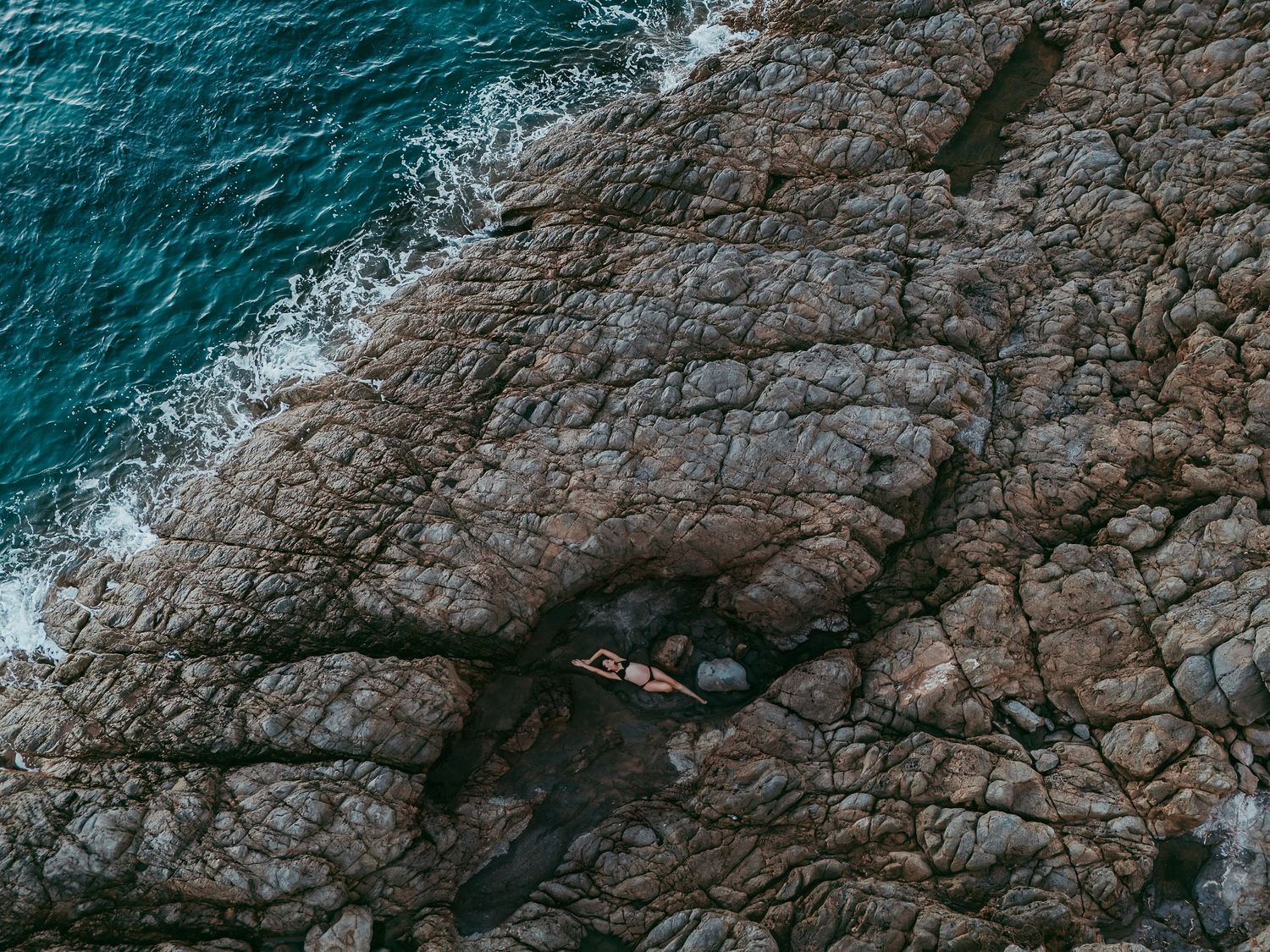 Maternity portrait of expecting mother reclining in natural rock pool – South Australia coastal photography