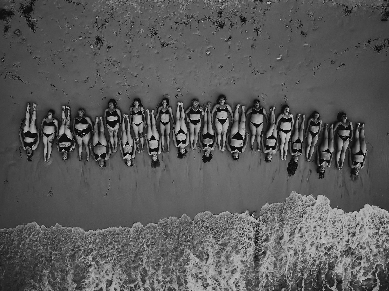 A group of women laying on the sand near the waters edge.  Women's empowerment photographer, Adelaide South Australia